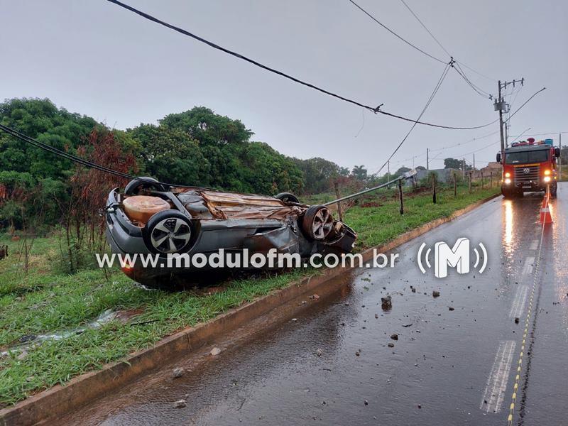 Veículo capota após colisão com poste e condutor escapa...